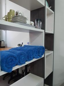 uma fila de toalhas numa prateleira numa cozinha em ROOMMATE STUDIO em Kuah