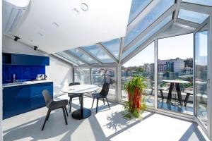 Juno Hotel Taksim في إسطنبول: مطبخ مع طاولة وكراسي ونوافذ زجاجية