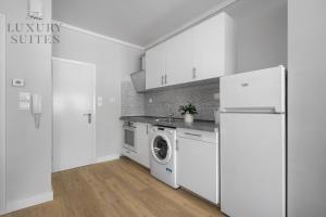 a white kitchen with a refrigerator and a washing machine at Nephele, The Luxury Suites in Thessaloniki