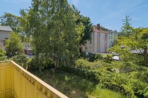 a yellow fence with a tree and buildings at Studio with Balcony 300m to the Beach Sopot by Renters in Sopot