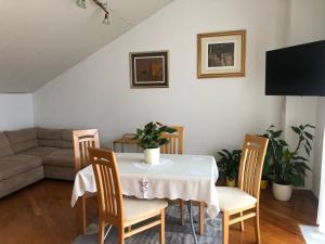 een woonkamer met een tafel, stoelen en een bank bij Apartment Bojana in Novi Vinodolski