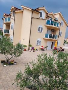 a large apartment building with trees in front of it at Vila Meri in Vodice