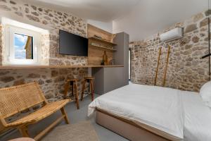a bedroom with a bed and a tv and a chair at Murvica resport in Murvica