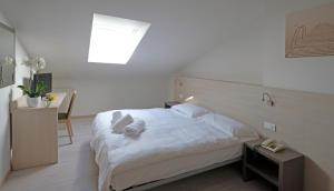 - une chambre avec un lit doté de draps et d'oreillers blancs dans l'établissement Hotel Gelmini, à Vérone