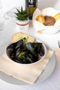 a bowl of mussels on a plate on a table at Hotel Plaza in Cattolica