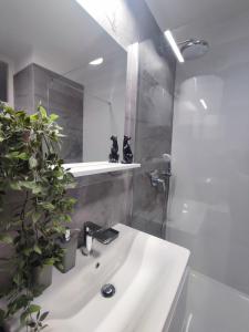 uma casa de banho com um lavatório branco e um chuveiro em Apartman Ivan em Kaštela