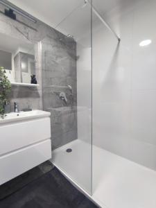 uma casa de banho branca com um chuveiro e um lavatório. em Apartman Ivan em Kaštela