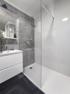 a white bathroom with a shower and a sink at Apartman Ivan in Kaštela +16 photos