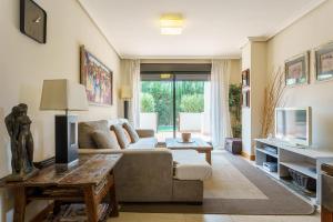 salon z kanapą i telewizorem w obiekcie Luxurious and spacious apartment with a private garden and solarium with great views in Estepona área Marbella La Resina Country Golf w mieście Estepona
