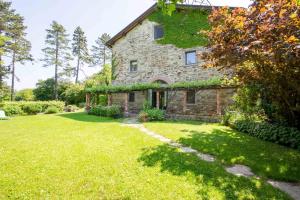 a large stone house with a grass yard at Casa Palmira in Polcanto