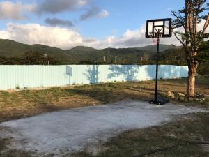 a basketball hoop in a field with a tree at XingYe B&B in Checheng