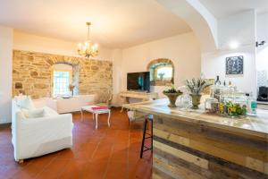 uma cozinha e sala de estar com uma parede de pedra em Casa Palmira - La Casina em Polcanto