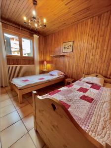 萊熱的住宿－Résidences Delavay La Cordée，小木屋内一间卧室,配有两张床