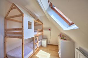 Cama elevada en habitación con ventana en Les Roséales - Maison proche plage pour 6 voyageurs, en Courseulles-sur-Mer