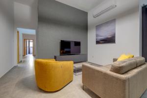 een woonkamer met een bank en een tv bij Modern 3BR Apartment in Sliema's Desirable Locale in Sliema