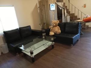 a teddy bear sitting on a couch in a living room at XingYe B&B in Checheng