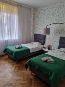 una camera con due letti con lenzuola verdi di Apartament na Żeromskiego a Gdynia