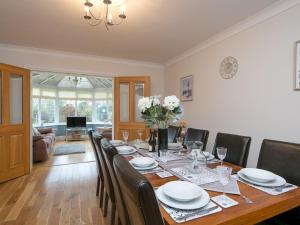 a dining room with a long table and chairs at Pass the Keys Cysgod Eryri Spacious House near Anglesey Coast in Brynteg