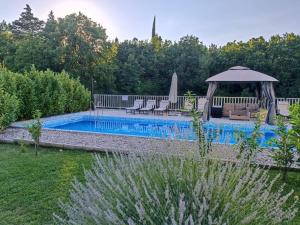 a swimming pool in a yard with a gazebo at Kuća za odmor -FourM in Novak