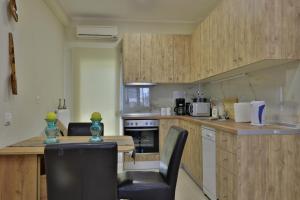 a kitchen with wooden cabinets and a table and chairs at antonis new apartment's 1 in Katerini