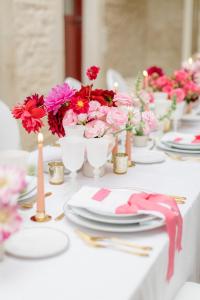 une table blanche avec des assiettes, des fleurs et des bougies dans l'établissement Les Sarments, à Santenay