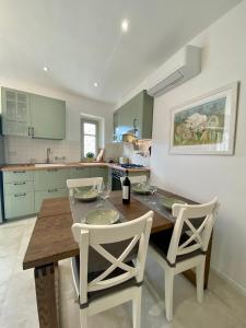 una cucina con tavolo in legno e sedie bianche di Casa Marina a Radda in Chianti