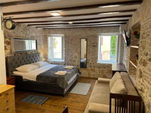 - une chambre avec un grand lit et un canapé dans l'établissement Tequila Apartments, à Zadar
