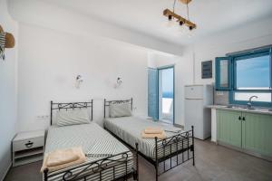 1 dormitorio con 2 camas y cocina con fregadero en Alcyone, en Serifos Chora