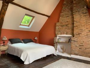 1 dormitorio con 1 cama grande y pared de ladrillo en L'Authentique maison de charme, en Aubusson