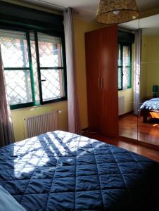 1 dormitorio con 1 cama azul y 2 ventanas en Parco Madonnetta en Acilia