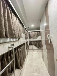 ein Badezimmer mit Vorhängen und einer Dusche mit Handtüchern in der Unterkunft AVIRAHI HOTEL in Mumbai