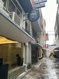 曼谷Dreamcatcher Bangkok的坐在商店窗户上的男人
