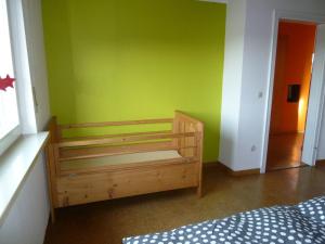 ein Schlafzimmer mit einer grünen Wand und einer Holzbank in der Unterkunft Ferienwohnung Gäckle in Bad Liebenzell