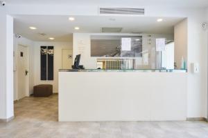a lobby with a large white counter in a room at Hostal Gami Adults Only in Cala Ratjada