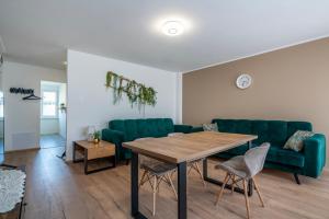 een woonkamer met een tafel en groene stoelen bij 13 Gdynia Centrum - Apartament Mieszkanie dla 5 os in Gdynia