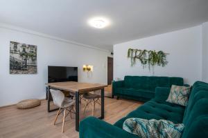 a living room with a green couch and a table at 13 Gdynia Centrum - Apartament Mieszkanie dla 5 os in Gdynia