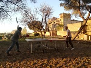 two men playing ping pong on a ping pong table at Maison Entière Hameau Monastir del Camp in Passa
