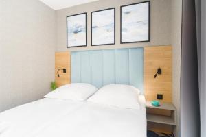 sypialnia z łóżkiem z trzema zdjęciami na ścianie w obiekcie Mielno Hotel Boutique w mieście Mielno