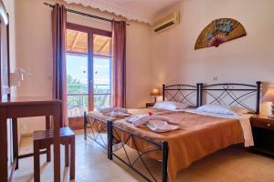 a bedroom with a bed with a table and a window at Hotel Olga in Agios Stefanos