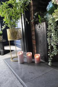 tre candele sedute su un pavimento accanto a una sedia di CARAMBOLA LUXURY AIR BNB IN THE HEART OF BEVERLEY a Beverley