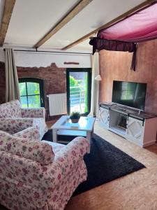 a living room with a couch and a tv at Raminorca Ferienwohnung - Frühstück kann man bei uns dazu buchen in Ramin