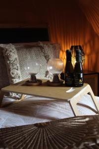 CARAMBOLA LUXURY AIR BNB IN THE HEART OF BEVERLEY في بيفرلي: طاولة مع مصباحين وزجاجات فوق السرير