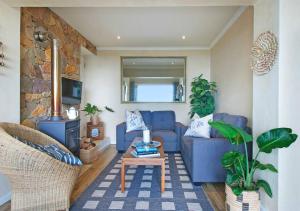 een woonkamer met een blauwe bank en een tafel bij Vitamin-Sea in Kaapstad