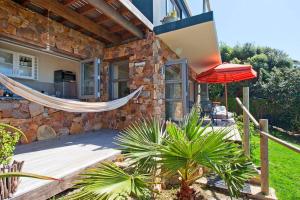 a house with a hammock outside of it at Vitamin-Sea in Cape Town