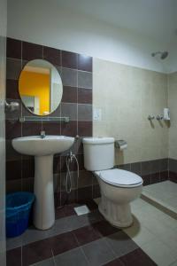 La salle de bains est pourvue de toilettes, d'un lavabo et d'un miroir. dans l'établissement SC Hotel Melaka, à Malacca