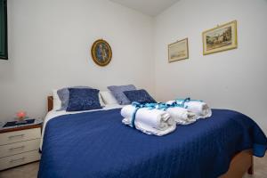 Un dormitorio con una cama azul con toallas. en La casa di Marigiò, en Piraino