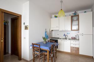 une cuisine avec une table et des placards blancs dans l'établissement La casa di Marigiò, à Piraino