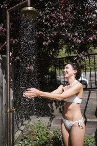 Una donna in bikini davanti a una fontana di Feel good Resort Johannis a Tirolo
