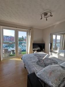 a bedroom with a bed and a large window at Apartment by the Beach in Swansea