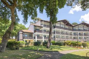 duży budynek z drzewami przed nim w obiekcie Appartement Olivia w mieście Moliets-et-Maa